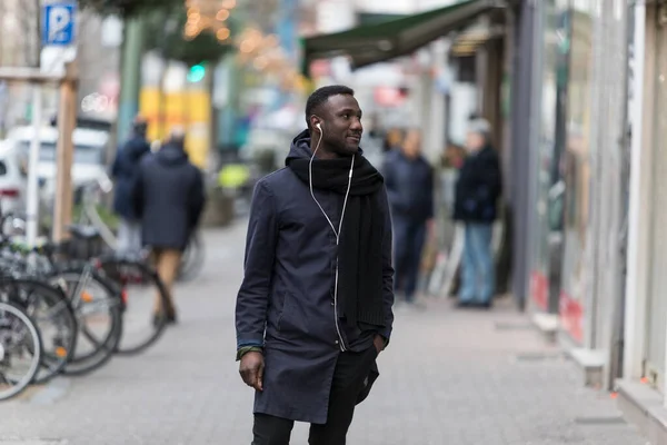 Joven Hombre Negro Con Mano Bolsillo Auriculares Pie Acera Con —  Fotos de Stock