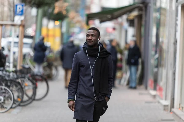 Joven Hombre Negro Con Auriculares Abrigo Invierno Caminando Por Calle — Foto de Stock