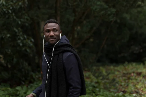 Joven Hombre Negro Caminando Con Auriculares Parque Mirando Hacia Otro — Foto de Stock