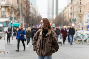 Duyan genç beyaz kadın arkasını döndü ve arka plandaki kalabalıkla yüzünü çevirdi..
