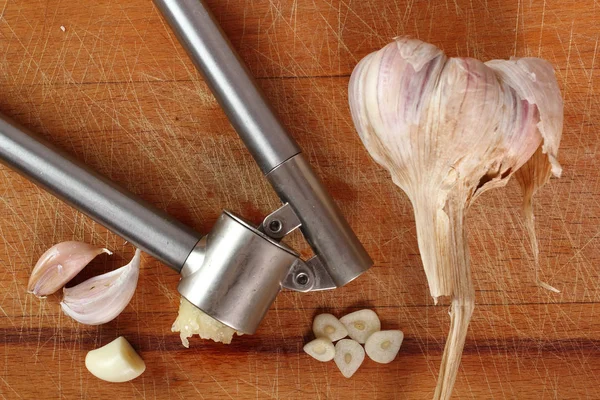 Sliced, crushed garlic and garlic press