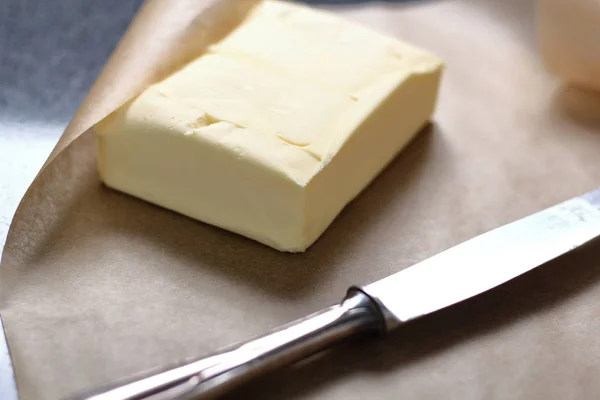 Block butter on parchment paper amd table knife