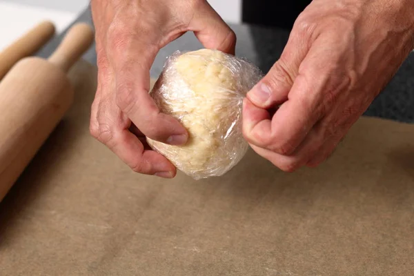 Unwrapping dough ball from plastic film. Making Cider Pie Series.