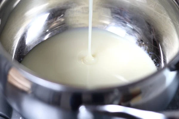 把甜的浓缩牛奶倒入锅中 制作波士顿香蕉派 — 图库照片
