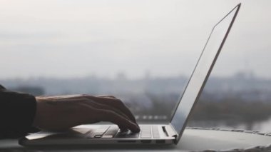 Erkek parmaklar ve parmaklar dizüstü bilgisayarın klavyesinde yazıyorlar. İşadamı elleri ofis bilgisayarının klavyesinde daktilo çalıyor. İş konsepti