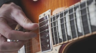 Parmak stili gitarist gitarda şarkı çalışıyor. Gitar çalan ve çalan eller. Manzarayı kapat. Müzik konsepti