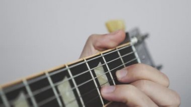 Eller ve parmaklar elektro gitarda pratik yapıyor. Yakın görüş. Erkek eller parmak stili caz ya da blues şarkısı çalıyor..