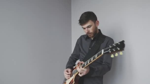 Чоловік з бородою грає на соло-електричній гітарі ізольовано. Руки, що грають на електрогітарі, практикують рок-н-рольний концерт . — стокове відео