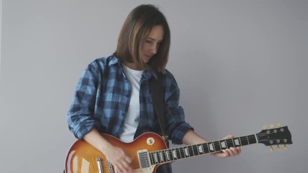 Junge süße Frau mit E-Gitarre, die Lieder spielt und tanzt. Frau mit E-Gitarre übt vor Rockkonzert — Stockvideo