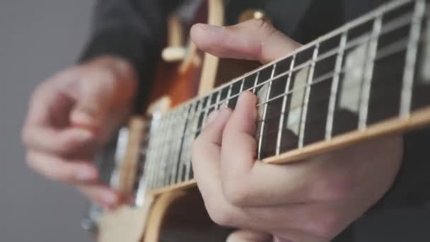 Männliche Hände, die aus nächster Nähe auf der E-Gitarre spielen. Finger auf dem Griffbrett der Gitarre halten Plektren und spielen Akkorde und Solo. Musikinstrumentenkonzept — Stockvideo