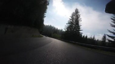 Bisikletçi. Pov, orijinal bakış açısı. Bisikletle dağ geçidinden yokuş aşağı hızla iniyoruz. Atletik erkek, ormanda yokuş aşağı gidiyor.