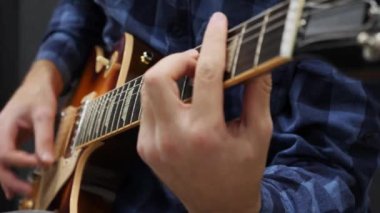 Erkek eller gitarda oynuyor. Elektro gitarda solo çalan profesyonel bir gitarist. Genç adam müzik enstrümanında şarkı söylüyor. Gitar dersleri