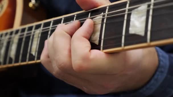 Dedos humanos tocando na guitarra de perto. Músico profissional tocando sozinho. Mãos masculinas no violão tocando acordes. Aulas de música de guitarra — Vídeo de Stock