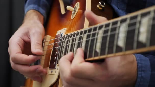 Hombre tocando la guitarra. Guitarrista profesional tocando jazz o blues solo en guitarra eléctrica usando pick. Concepto de instrumentos musicales — Vídeo de stock