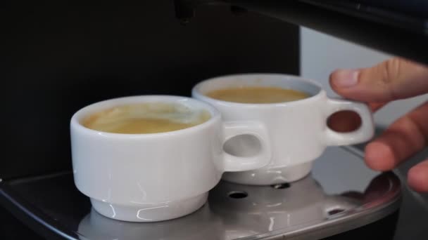 男の手はプロのコーヒーマシンから準備コーヒーを取り出します。コーヒーメーカーはエスプレッソを用意した。コーヒーマシンはコーヒーを作るために終わった — ストック動画