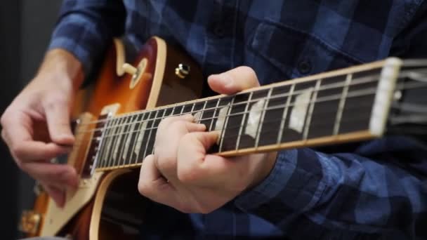 Een man die gitaar speelt. Professionele gitarist houdt pick and playing solo op elektrische gitaar. Close-up van mannelijke vingers die jazz of blues uitvoeren. Muziekinstrumentenconcept — Stockvideo