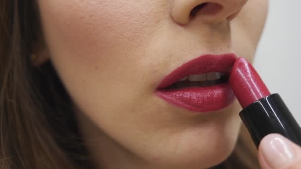 Vrouw die lippenstift aanbrengt. Make-up in uitvoering. Vrouw die rode lippenstift schildert. Vrouwelijke handvat buis van lippenstift. Langzame beweging — Stockvideo