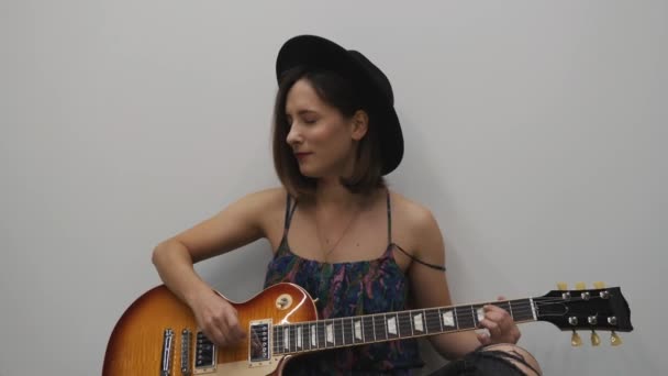 Egy nő elektromos gitárral country stílusú zenét játszik. Hangszerkoncepció. Női gyakorló gitár — Stock videók