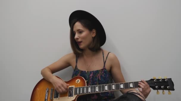 Mujer tocando la guitarra eléctrica. Mujer tocando música country en la guitarra. Elegante chica joven tocando en la guitarra — Vídeos de Stock