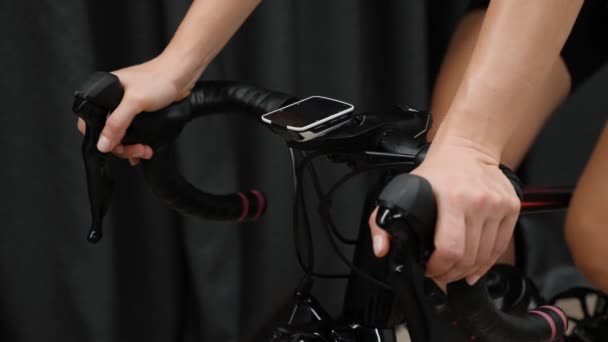 Kadın elleri bisiklet gidonunu tutarken bilgisayardan kalp hızı verilerini gösteriyor. Akıllı antrenörde kapalı alanda bisiklet eğitimi. — Stok video