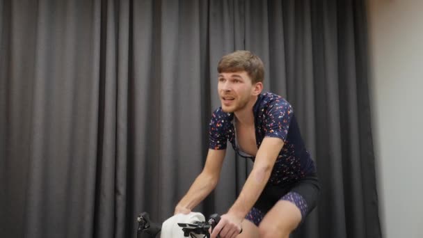 Koncepcja jazdy na rowerze. Człowiek na rowerze inteligentny trener. Profesjonalny rowerzysta przygotowuje się do wyścigów na rowerze w domu. Mężczyzna ciężko trenuje na rowerze i poci się. Koncepcja utraty wagi — Wideo stockowe