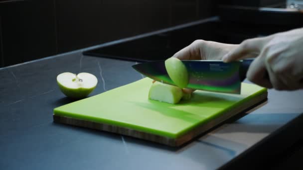 Mutfakta yeşil meyveleri kesen kadın elleri. Kadın yeşil tahta üzerinde elma kesiyor, yakın plan. Organik sağlıklı yiyecekler. Sağlıklı beslenme — Stok video