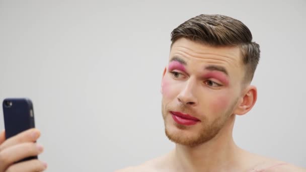 Profesionální parodie umělec dělat selfie na telefonu. Mladý muž s transsexuální make-up fotografování sebe na smartphonu, zblízka — Stock video