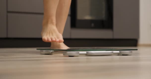 女人的腿在检查体重 女性赤脚在天平上测量重量，近身。 体重减轻概念 — 图库视频影像