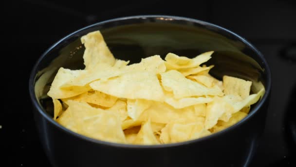 Collations à la bière dans un bol, fermer. Un homme qui ajoute des cacahuètes dans le bol. Chips et noix dans le plat. Assiette pleine de nachos, gros plan — Video