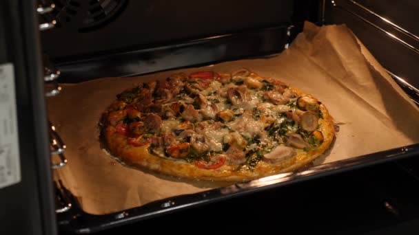 Kvinna kock få bakad pizza från ugnen. Matlagning pizza hemma, kök. Färdiglagad pizza — Stockvideo