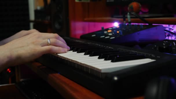 Manos tocando en el teclado de piano midi en el estudio de música casera. Primer plano de músico creando una nueva canción para el álbum de música. Estudio de grabación. Estación de trabajo de audio digital — Vídeo de stock