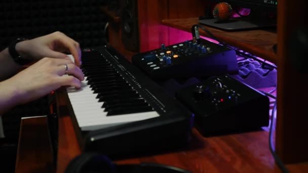 Ingeniero de sonido de mezcla y masterización en la estación de trabajo de audio digital. Músico compositor tocando piano midi teclado en el estudio de música casera con monitores de mezcla — Vídeo de stock