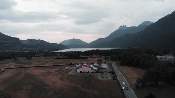 Paragliding base from bird's eye view. Drone flying around hang gliding center. Lake Annecy France and mountains — ストック動画