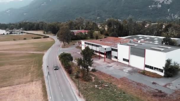 Cyklisté jedoucí v horách Alp poblíž obce Doussard ve Francii, drone výstřel pohled. Dron pohled na venkovské silnici a muži na kolech na koni kolem hor — Stock video