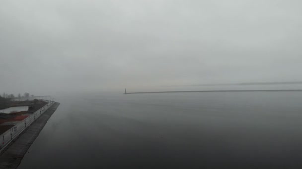 Niesamowity widok drona z nabrzeża miasta z samicami i samcami biegnącymi wzdłuż brzegu rzeki. Ludzie biegają wzdłuż nabrzeża w ramach codziennej rutyny. Sportowcy wykonujący treningi na świeżym powietrzu — Wideo stockowe