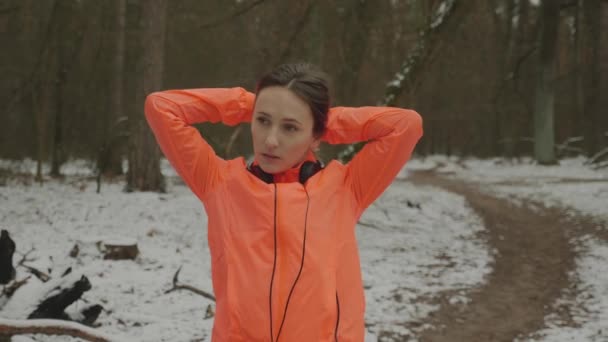 A fêmea amarra a cauda. Mulher amarrando a cauda antes de executar exercícios no parque de inverno. Atleta feminina se preparando para o treinamento de corrida ao ar livre. Trail run concept. Movimento lento — Vídeo de Stock