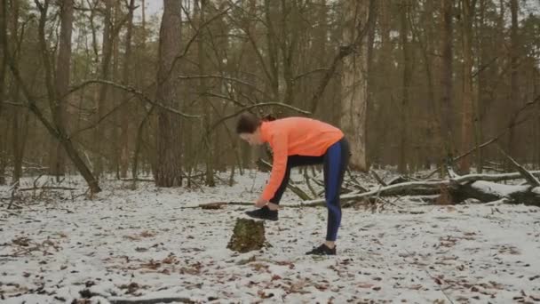 Urheilija sitoo kengännauhoja. Nuori urheilullinen nainen sitoo kengännauhat lenkkarit puistossa ja valmistautuu run koulutus. Nainen sitomassa kengännauhoja ja valmistautumassa ulkoiluun. Polkuajokonsepti — kuvapankkivideo