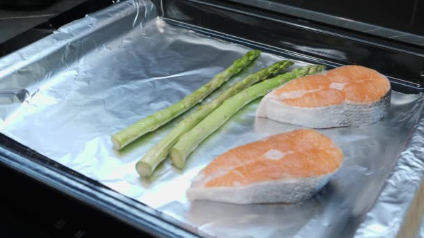 Chef zet groenten op bakplaat. Proces van het koken van vis steak. Vrouw kookt gezond eten in de oven in de slimme keuken. Groenten in de keuken. Thuis koken — Stockvideo