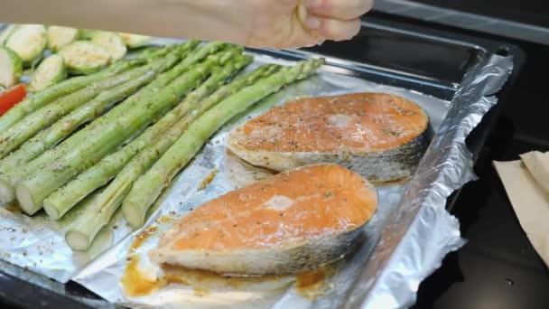 Hände, die Zitrone auspressen und roten Lachs mit Zitronensaft bestreuen. Lachs mit Zitronensaft würzen. — Stockvideo