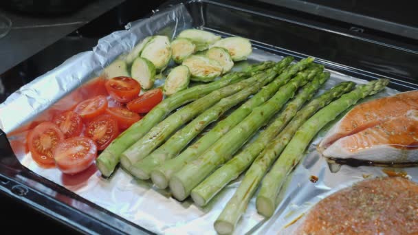 Rosenkohl und grüner Spargel mit Tomaten und Forellenlachs, gewürzt mit Pfeffer und Gewürzen. — Stockvideo