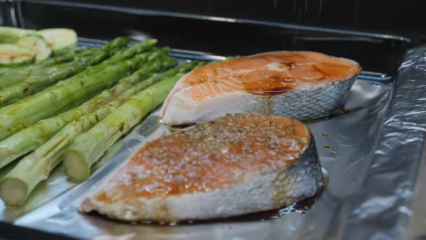 Twee stukken rode zalm worden gekruid met rode peper zout en specerijen voor het grillen. — Stockvideo