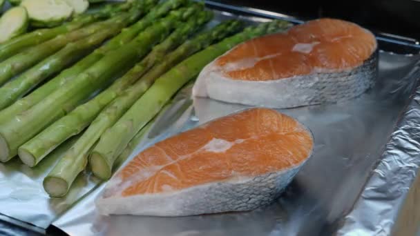 Hands pouring olive oil on red salmon slices before cooking in the oven. — 비디오