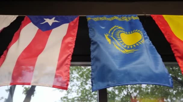 Närbild av en grupp flaggor. Flaggor från olika länder hänger på väggen. Nationella flaggor från olika nationer — Stockvideo