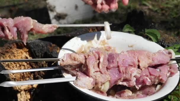 O cozinheiro-chefe põe carne no espeto. Carne em marinada de cebola. Churrasco ao ar livre. Cozinhar carne na grelha — Vídeo de Stock