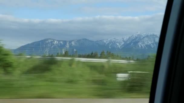 美しい山の背景。山、屋内ビューを介して車に乗る。車の窓から山頂。男は山を背景に高速道路に沿って車を運転 — ストック動画