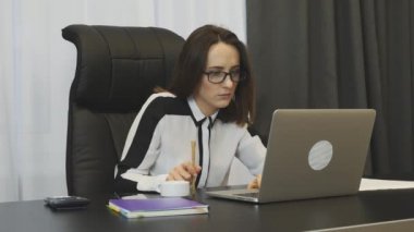 Woman waiting for answer of job promotion, checking her email box on laptop in office. Young female employee worried about mistakes on her job. Businesswoman looking on laptop screen and nervous