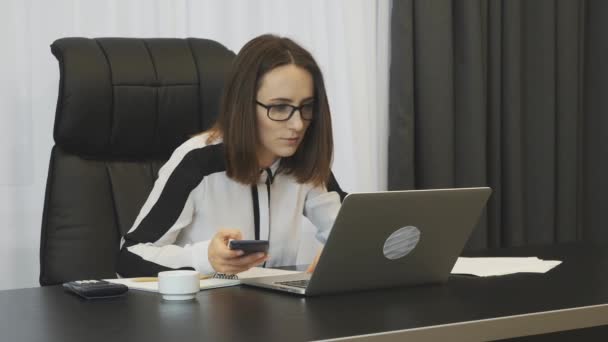 Business woman excited with good financial deal. Happy smiling woman celebrating successful job promotion in office. Female boss with phone enjoys finance results of company. Business success concept — Stok video