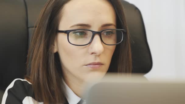 Das Gesicht der Geschäftsfrau blickt auf den Computerbildschirm. Nahaufnahme der schönen Frau Gesicht arbeiten auf Laptop. Chefin blickt auf Laptop-Monitor im Büro. Porträt einer Frau im modernen Büro — Stockvideo