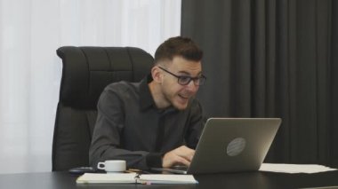 Man winning trade on stock market. Young trader won a trade at financial market. Businessman celebrating good news seen on laptop screen. Man excited with financial result of company. Victory concept