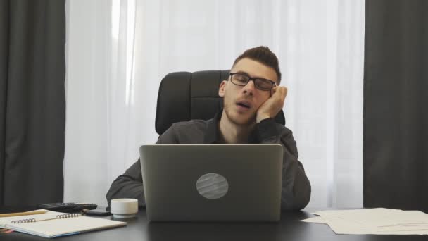 Man sleeping at workplace. Tired guy almost falling down sitting at his office desk. Broker rubbing eyes in business office. Young employee sleeping in office at working time. Male tired after work — Stok video